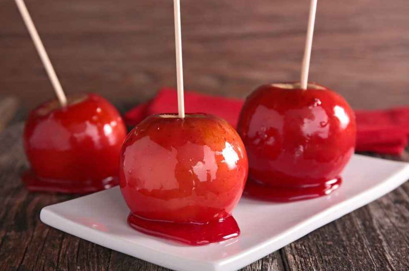 Maçã do amor Maçãs cobertas com uma camada brilhante de caramelo vermelho, uma opção deliciosa para os amantes de doces.